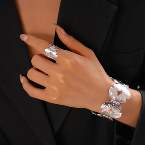 Detailed view of silver butterfly cutout jewelry set including an open ring and wide cuff