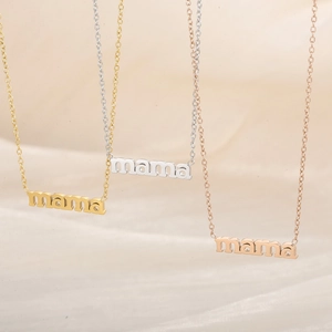 Three MAMA pendant necklaces in gold, silver and rose gold finishes on beige fabric