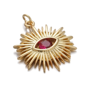 Macro shot of gold sun pendant featuring a central red evil eye zircon gemstone
