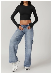 Slim fit black long sleeve crop top with thumbholes paired with ripped wide leg jeans