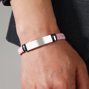 Close-up of a pink braided leather bracelet with a polished silver stainless steel plate
