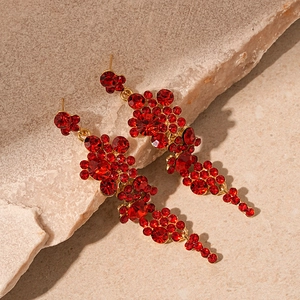 Detail of red crystal tassel earrings with sparkling rhinestones and gold-plated finish
