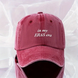 Macro detail of 'in my ERAS era' white embroidery on washed burgundy cotton baseball cap