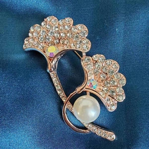 Detail of rose gold ginkgo leaf brooch with sparkling crystals and white pearl