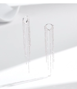 Macro detail of silver S925 heart earrings with long swaying fringe tassels