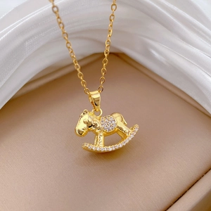 Elegant gold rocking horse necklace with sparkling pavé crystals on a silk background
