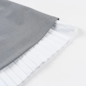 Elegant sleeveless gray and white pleated mini dress with boat neck and high contrast design