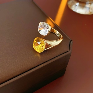 Detailed macro of golden open ring with square clear and amber crystal stones