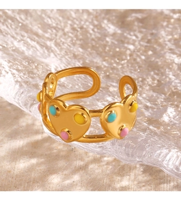 Détail d'une bague ajustable dorée avec cœurs en émail coloré sur verre texturé
