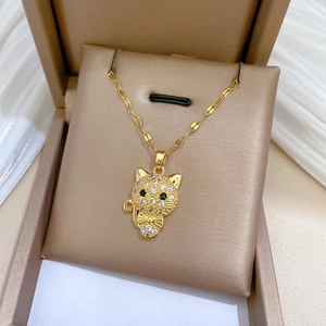 Luxurious gold cat pendant necklace with white crystals and bow detail in a gift box