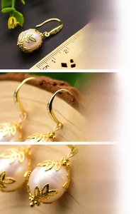 Detail view of baroque pearl earrings with gold leaf base and crystal hooks