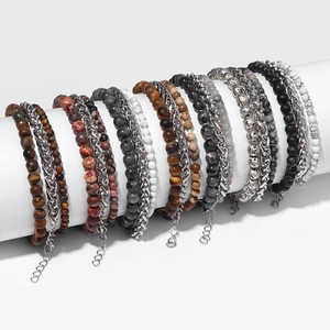 Close-up of stone bead and titanium steel chain bracelet set on a white display stand