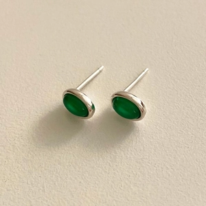 Macro shot of oval green agate stud earrings with polished 925 sterling silver base