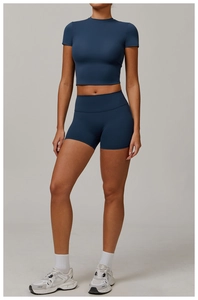 Detail of high-waisted seamless biker shorts and cropped t-shirt in navy blue matte fabric