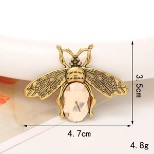 Detail shot of a vintage gold bee charm with champagne gemstone and size markings