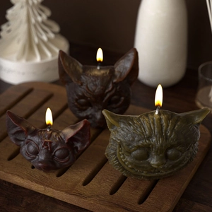 Sphynx and Cheshire cat head scented candles on a wooden tray for home decor