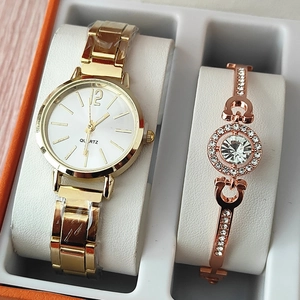 Close-up of gold quartz watch and rose gold rhinestone bracelet set in a gift box