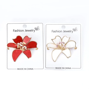 Close-up of red and white lily brooches with crystal rhinestones on a display card