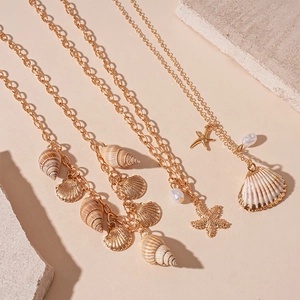 Boho layered necklace set with gold sea shells, starfish, and pearl pendants for beach vacation