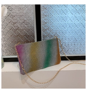Close-up of rainbow gradient rhinestone evening clutch bag with golden chain strap
