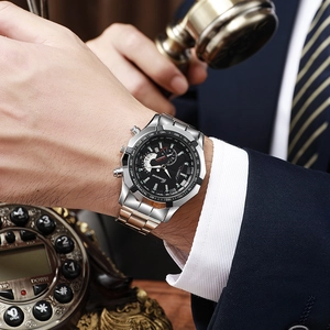 Detail of luxury men's steel watch with black dial and tachymeter on a business suit