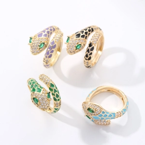 Detail of four brass gold plated snake rings with colorful enamel and zircon stones