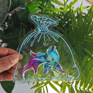 Close-up of holographic suncatcher window film with colorful fish design and rainbow reflection