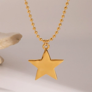 Detail of gold star pendant necklace with mirror finish on a sleek ball chain