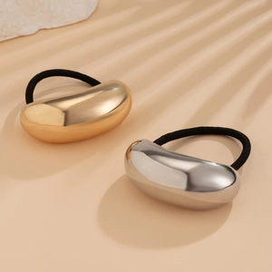 Detail of elegant gold and silver oval metal charms on elastic black hair ties