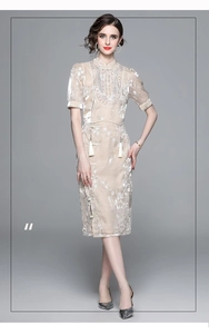 Close-up of beige satin Chinese style top with intricate floral embroidery and silk tassels