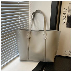 Detail shot of light grey soft leather tote bag showing large capacity and smooth texture
