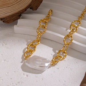 Bracciale a catena grossa dorata con perla barocca bianca su espositore in legno