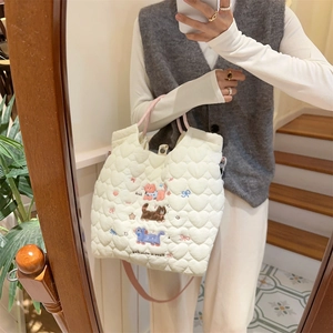 Quilted white shoulder bag with cat embroidery and pink straps in a mirror selfie