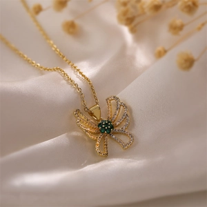 Macro shot of gold-plated hollow butterfly pendant with white and emerald zircons
