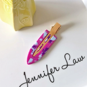 Detailed close-up of marble pattern acetate hair clip with golden metal fastener