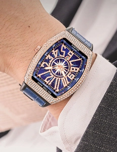 Macro shot of rose gold tonneau watch case with sparkling rhinestones and blue dial