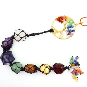 Detailed close-up of natural 7 chakra crystal stones in hand-woven black net with Tree of Life