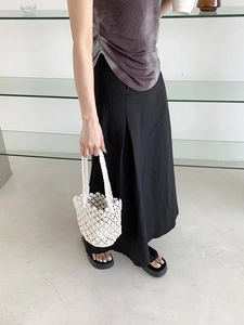 Chic beige hand-woven bucket bag styled with casual tie-dye outfit and skirt