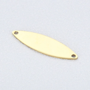 Détail d'un pendentif doré en acier inoxydable en forme de feuille à double perçage