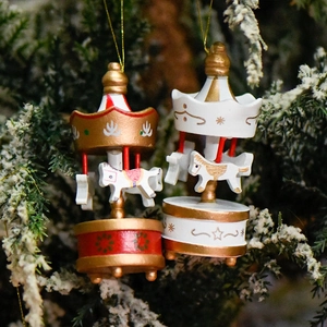 Hand-painted Christmas mini carousel ornaments in red and white hanging on a festive tree