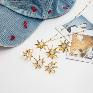 Flat lay of gold sun jewelry set with opal stones on denim background with photos