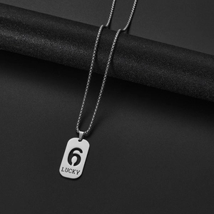 Macro shot of silver rectangle pendant with hollow number 6 and Lucky engraving