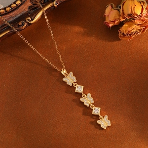 Detailed close-up of golden butterfly pendant necklace with zircon on vintage background