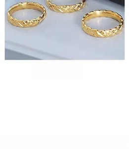Macro shot of gold-plated quilted rings featuring minimalist Criss-cross engraved details