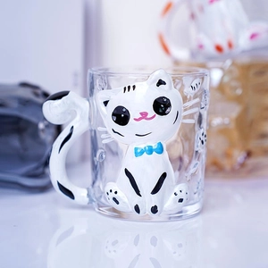 Detail of 3D white cat figurine glass mug with blue bowknot and cat tail shaped handle