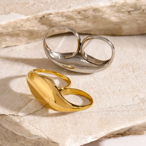Minimalist thick stainless steel rings in gold and silver finish on natural stone