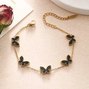 Detail view of gold butterfly bracelet with black charms and adjustable lobster clasp