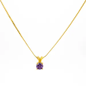 Detail of gold rope chain necklace featuring a four-prong set round purple gemstone pendant