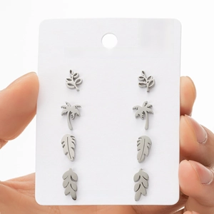 Detail of four pairs of stainless steel stud earrings featuring leaf and palm tree designs