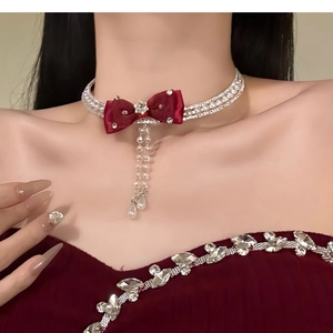 Detail of velvet bow choker with rhinestone fringe and pearl pendants on neck